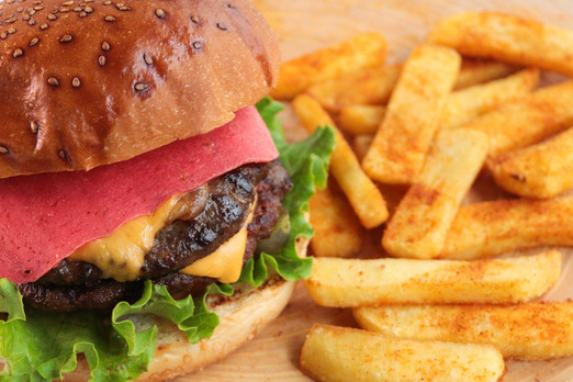 Frischer Burger mit knusprigen Pommes und saftigem Fleisch im Brötchen serviert